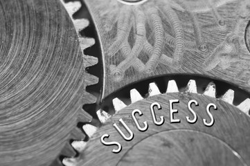 Background with the inscription Success. Black white background with metal cogwheels clockwork. Macro. Conceptual photo for your successful business design. Metallic black and white letters, gears.  