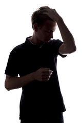 silhouette portrait of a stylish guy, young man holds his hand through his hair on a white isolated background