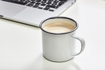 Telework desk at home office in the morning with a printable vintage mug and laptop
