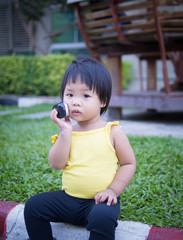 child girl sitting and holding mobile phone to talking