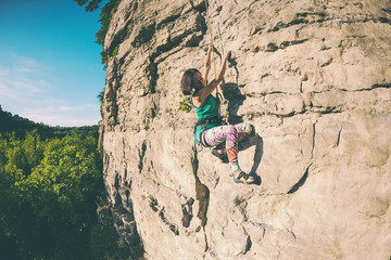 Obraz premium The girl climbs the rock.
