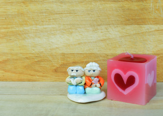 Romantic with couple doll and aroma candle on wood backgrounds