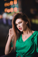 Fototapeta premium Emotional portrait of Fashion stylish sexy of young hipster blonde woman, elegant lady, green top and red skirt, cool girl. City view urban dark cafe lifestyle background.