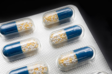 Six tablets per capsule type, blue on a black background