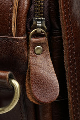 Zip fastener on a brown leather surface close-up