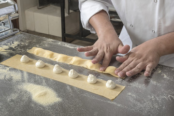 Closing individual Ravioli with stuffing. Preparing freshly made Raviolis with Mascarpone cheese