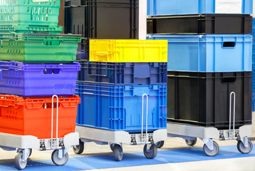 colorful plastic boxes stacked one upon the other on warehouse trolley or platform trolley