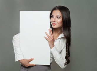 Naklejka premium Young businesswoman holding white blank paper banner background with copy space for advertisiment. Business success, advertising marketing or education concept