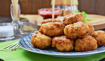 Meatballs on plate over over green napkin, salt cellar and tableware in the backbround