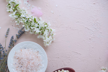 SPA and bathroom accessories. Photo in pink colors. Live flowers and bath salt. Copy space.