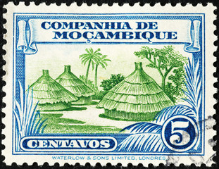 Tribal huts on vintage stamp of Mozambique