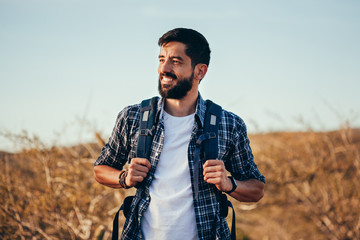 Happy young man hiking with backpack - Powered by Adobe