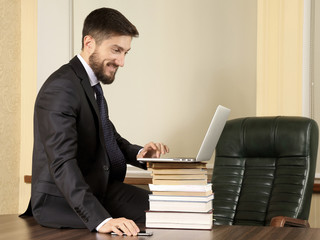 Naklejka premium successful business man sitting at office table and working with laptop