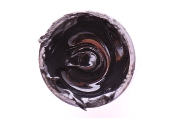 Black the Color Isolated. Open, full bin of black paint. White background