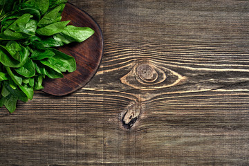 Spinach baby leaves on wooden background. Top view. Copy space