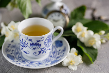 Obraz na płótnie Canvas A cup of original tea set and delicate jasmine flowers.