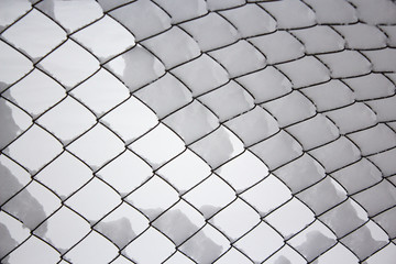 Mesh fence under a thick layer of snow after snowfall