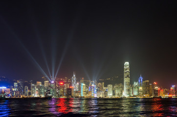 Hong Kong city skyline with light show and reflections on the water, seen from Kowloon