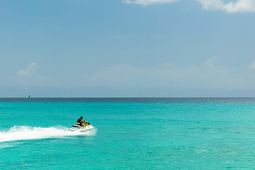 Fototapeta na wymiar Jet ski rider on tropical pristine beach in Barbados