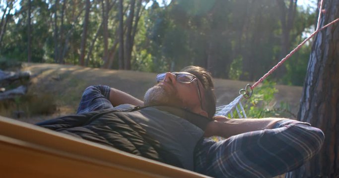 Man relaxing in a hammock on a sunny day 4k