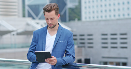 Young businessman work on tablet computer at outdoor