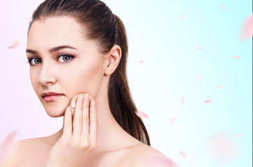 Beautiful woman over fresh blue background with swirl petals.