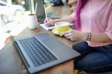 Woman typing on notebook with blank screen, sitting at wooden ta