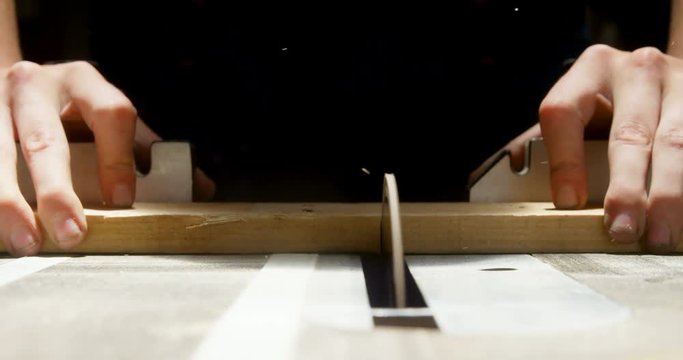 Female welder using table saw on a wooden plank in workshop 4k