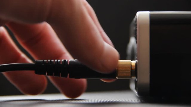 Unplugging headphone cable from the headphone jack. external sound card,mixer in home studio of musician.