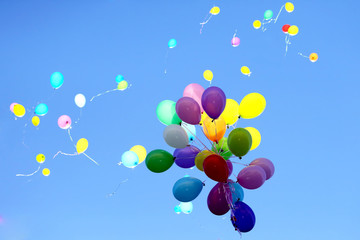 many multicolored balloons flying in the blue sky