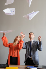 A business woman and man throwing papers up