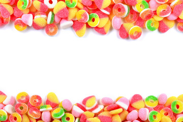 Frame of assorted gummy candies isolated on white. Top view. Space for text or design.