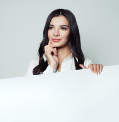 Confident woman thinking and holding white empty blank paper banner background