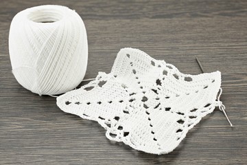 A doily is crocheted from white yarn