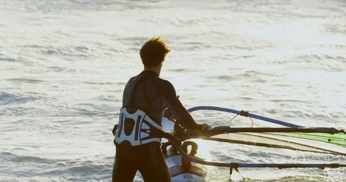 Male surfer windsurfing in the beach 4k