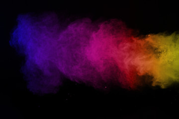 Freeze motion of colored dust explosion isolated. Colorful powder explosion on black background.