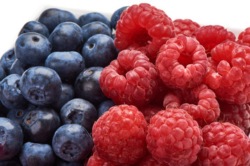 Blueberries and raspberries, isolated on white background. Close-up.