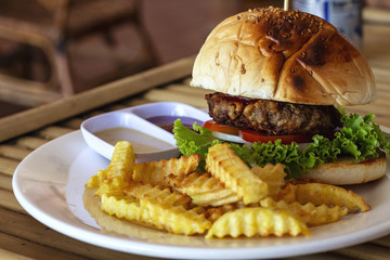 Tasty fresh burger and french fries on white plate served for lunch. Yummy kids food menu closeup photo.