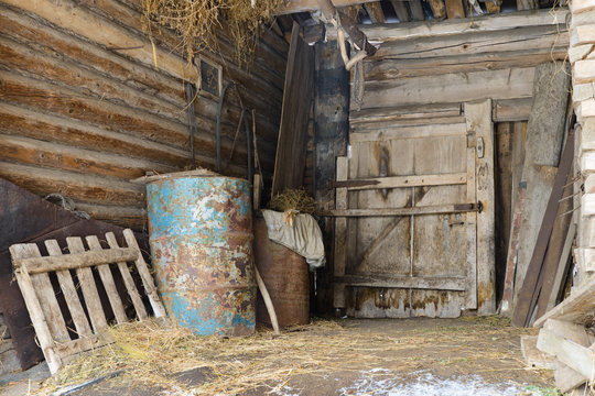 old abandoned barn with metal barrels and old things