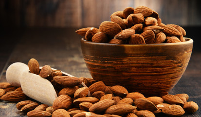 Bowl with shelled almonds on wooden table