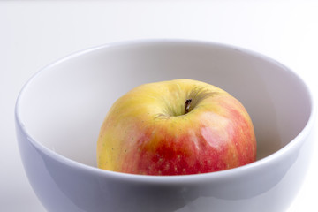 fresh red apple in a white breakfast bowl