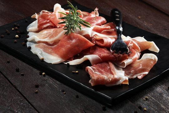 Italian prosciutto crudo or jamon with rosemary. Raw ham