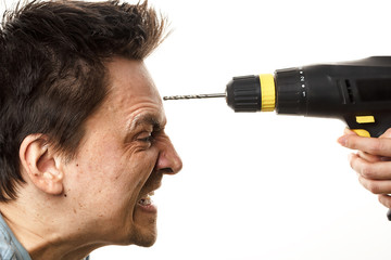 A drill in female hands is aimed at the forehead of an angry, disheveled man. The concept of female...