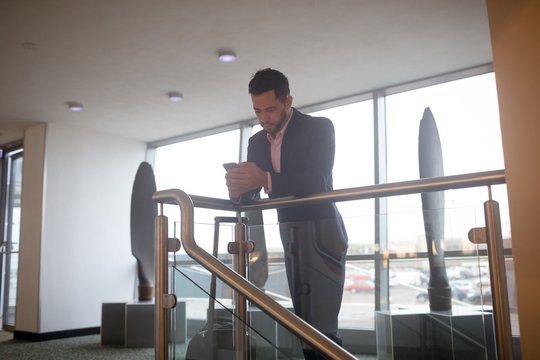 Businessman using mobile phone at corridor
