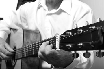 Fototapeta premium The musician in a white shirt playing acoustic guitar