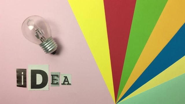 Bombilla moviendose junto a la palabra &ldquo;idea&rdquo; sobre fondo de colores.