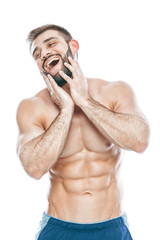 Fototapeta premium He stroked and touched his beard. A beautiful beard. Beautiful sporty guy male power. Fitness muscled in blue shorts. on isolated white background.