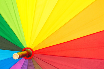 Multi-colored colorful umbrella with all colors of the rainbow. Bright texture background.