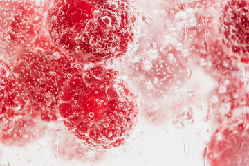 Fresh raspberries in water wiht air bubbles.