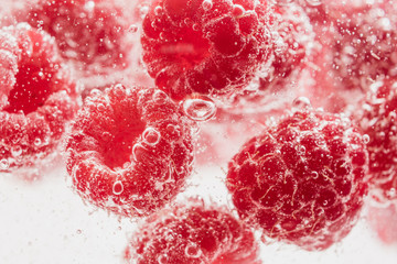 Fresh raspberries in water wiht air bubbles.